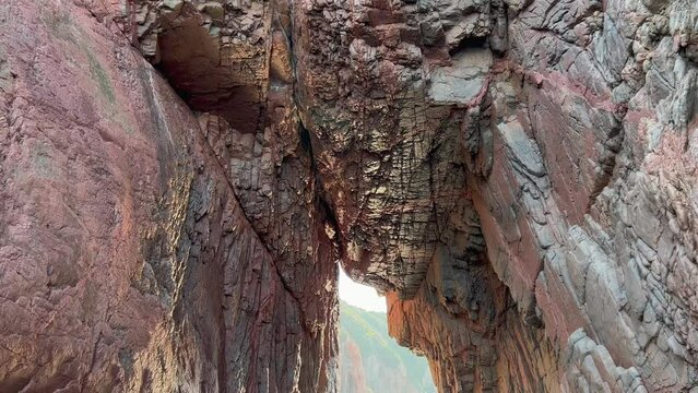Passing under Calanques de Piana rocky arch in Corsica island of France