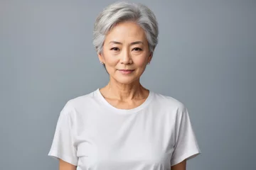 Fotobehang In portrait of beautiful Japanese, Korean, Asian woman with beautiful healthy facial skin Gorgeous elderly mature woman with short hair and happy smile. Beauty and cosmetics skin care advertising conc © jam