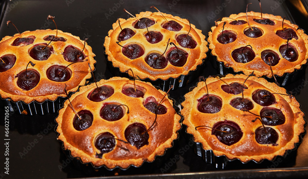 Poster Ready-made cherry pie in large and small form after baking in an electric oven