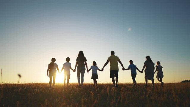 big family. huge community family holding hands walking in the park at sunset. happy family kid dream concept. big family community walking with children sunlight in the park. friendly people walking