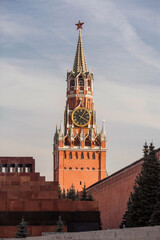 Obraz premium MOSCOW, RUSSIA - SEPTEMBER 26, 2023: The Kremlin's Spasskaya Tower on Red Square on a sunny autumn evening against a bright blue sky. A large clock and chimes on the Spasskaya Tower.