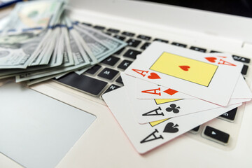 online gambling concept with laptop. Poker play card with dollar bills