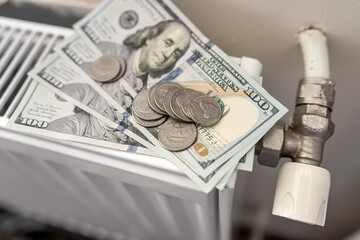 American paper dollar bills with coin cent on white radiator