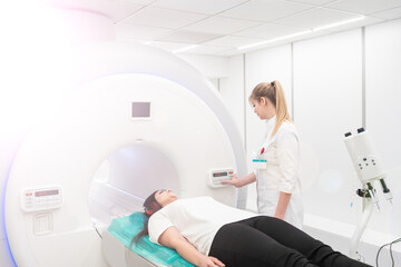 Female patient undergoing MRI - Magnetic resonance imaging in Hospital. Medical Equipment and Health Care - obrazy, fototapety, plakaty
