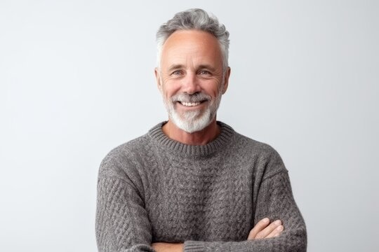 Portrait Of A Smiling Senior Man Standing With Arms Crossed Isolated On A White Background