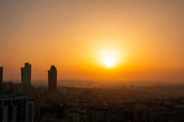 Obraz premium Istanbul cityscape with the reflection of the yellow color of the sunset on the skyscrapers.