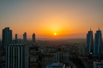 Obraz premium Istanbul cityscape with the reflection of the yellow color of the sunset on the skyscrapers.