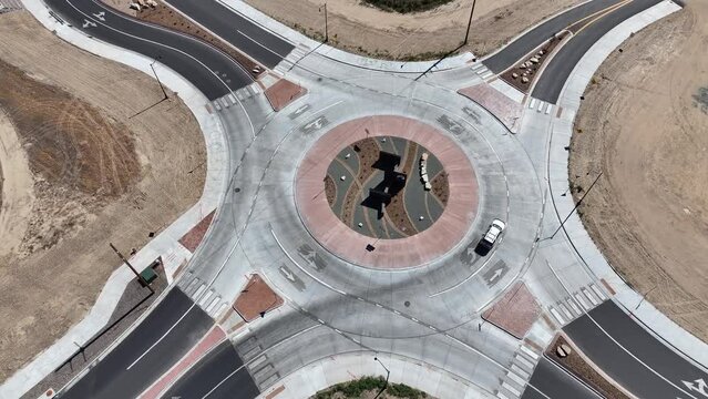 Cars navigate a roundabout in this dynamic drone shot.