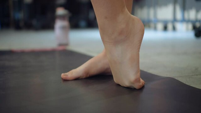 Feet Of Young Woman Stretching over a mat To Exercise In workout routine Barre Fitness Yoga Class health training