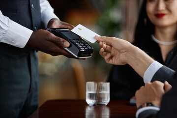 Side view close up of guest paying with credit card in luxury restaurant - obrazy, fototapety, plakaty
