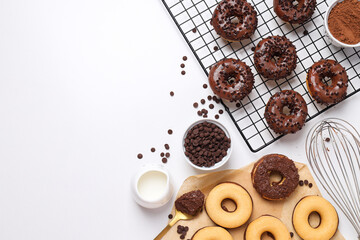 Chocolate donuts, bowls and whisk on white background, space for text