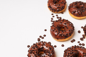 Chocolate donuts and chocolate chips on white background, space for text