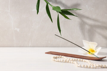 Flower, incense stick and bamboo on beige background, space for text