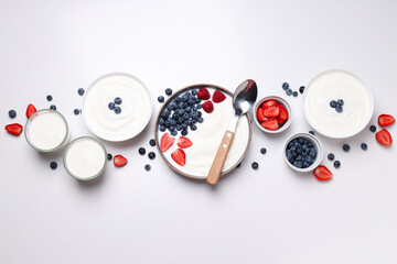 Bowls with yogurt and berries on white background, top view