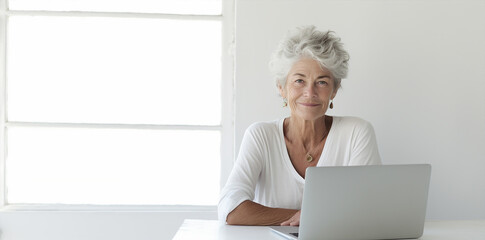 portrait of an l elderly  woman with long grey and white hair, working with computer pc in office