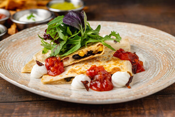 Mexican food molotes with sauces on wooden table