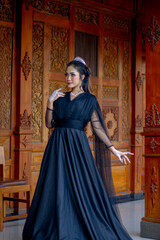 Naklejka premium Women's fashion model. Female makeup model. Asian woman. Indonesian women. wearing a black wedding dress. Black wedding dress.