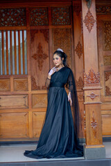 Naklejka premium Women's fashion model. Female makeup model. Asian woman. Indonesian women. wearing a black wedding dress. Black wedding dress.