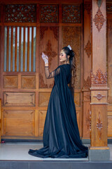 Naklejka premium Women's fashion model. Female makeup model. Asian woman. Indonesian women. wearing a black wedding dress. Black wedding dress.