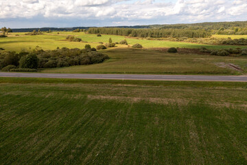Obraz premium Drone photography or rural road going through meadows and forest