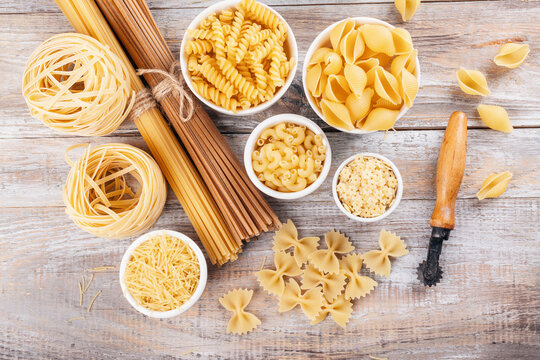 Pasta month. Assortment of uncooked pasta and noodles. Italian food culinary concept. Collection of different raw pasta on cooking table