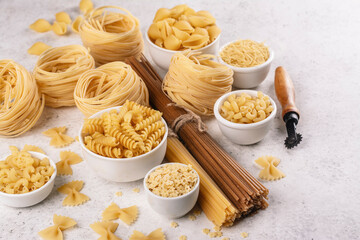 Pasta month. Assortment of uncooked pasta and noodles. Italian food culinary concept. Collection of different raw pasta on cooking table - obrazy, fototapety, plakaty