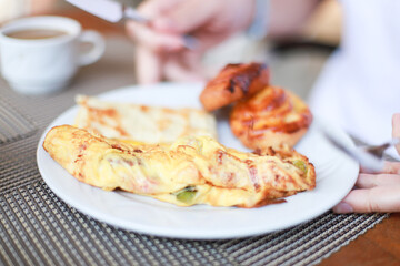 Omelet for breakfast. Man eating breakfast in hotel