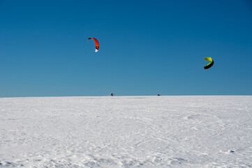 Kitesurfing in the snow with a blue sky
