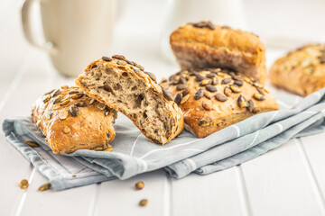 Whole grain bun with pumpkin seeds on napkin.