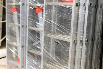 Aluminum extension ladders. Construction industry products shop. Metal staircase for workers.