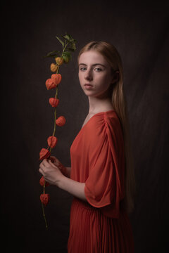 painterly portrait of young woman with orange lantern flower branch