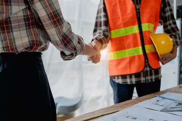 Engineers, designers and interior designers are handshake shack hands deal finalizing the design of...