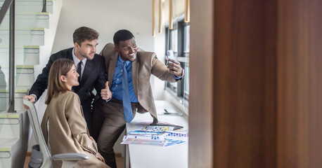 Multicultural colleagues celebrate project success with joyful, authentic conversation group selfie