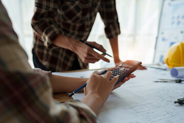 Fototapeta premium multi ethnic engineer brainstorming and measuring for cost estimating on blueprint and floor plan drawings about design architectural and engineering for houses and buildings