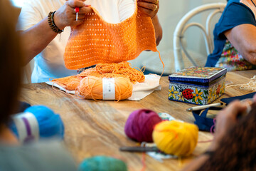 Fototapeta premium Crochet club. Ladies crocheting with colored wool.