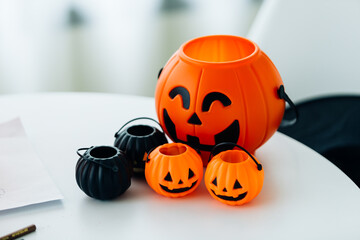 Halloween pumpkins with candies on white table, closeup