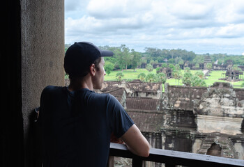 Unrecognizable European Tourist Contemplating The Jungle And the Ruins Of Angkor Wat