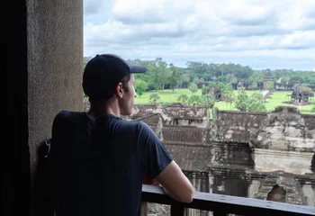Deurstickers Unrecognizable European Tourist Contemplating The Jungle And the Ruins Of Angkor Wat © Laia Balart