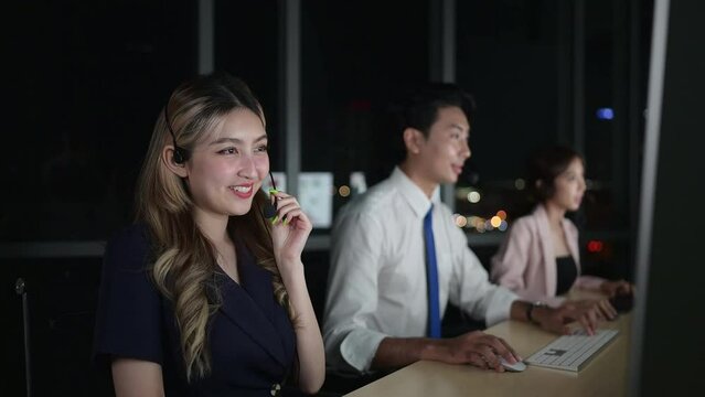 Group of broker international stock traders wearing headset working actively at night in office, Concept of customer support agent provide service on telephone.