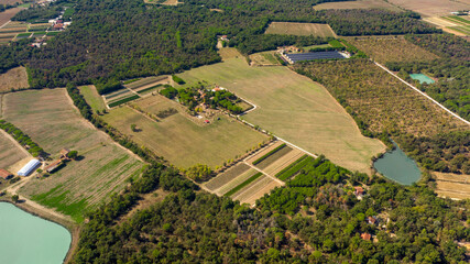 Fototapeta premium Aerial view of cultivated fields with small lakes and ponds.
