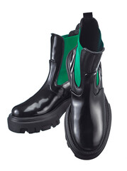 Beautiful pair of high demi-season boots made of glossy black leather with a green elastic band on the sides, with a massive sole, isolated on a white background. - 660358610