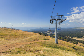 Chairlift on mountain landscape at summer day.