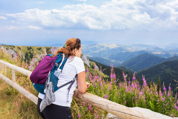 Fototapeta na wymiar Woman hiker enjoying summer nature landscape at mountains peak. 