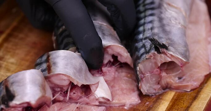 take mackerel during the preparation of a fish dish, raw butchered mackerel during cooking