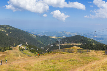 Chairlift on mountain landscape at summer day.