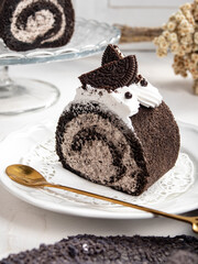 Oreo Sponge Cake is neatly presented on a plate with attractive decorations. It is isolated against a white kitchen background.