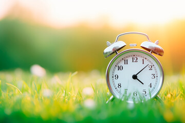 Alarm clock on the background of a summer landscape 