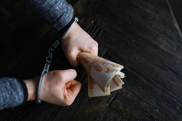 Handcuffs behind, five thousand rubles. Concept of corruption