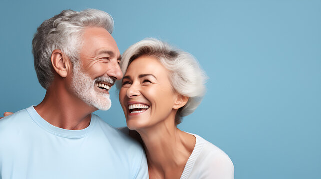 portrait of smiling elderly gray-haired couple couple happy pensioners man and woman with white perfect teeth isolated on blue background with copy space. Dental care. Dental prosthetics. Dentistry 