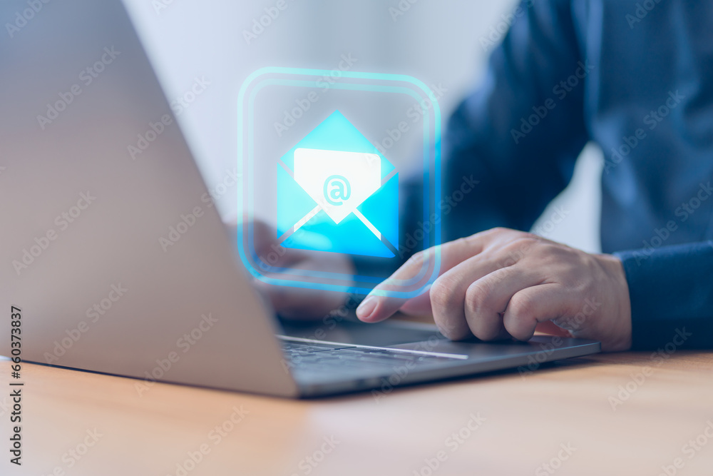Poster Concept of Email marketing, send e-mail or news letter, online working internet network. Male hand using a computer laptop typing on keyboard and surfing the internet on office table with email icon.